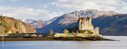 Pa noramic of Eilean Donan castle and bridge with water and mountains photo