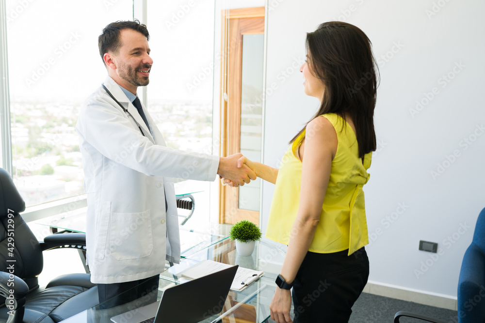 Attractive doctor greeting a woman in his office