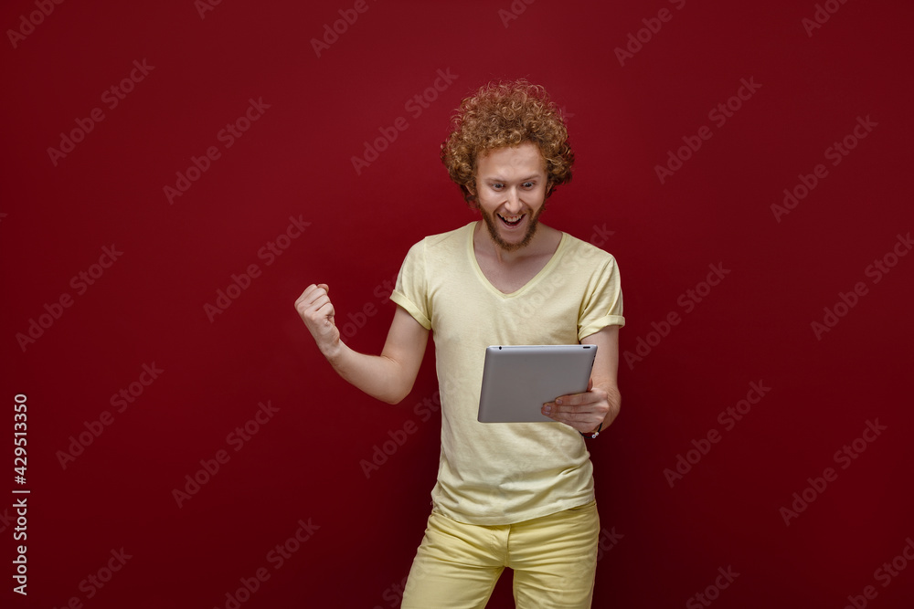 Young curly-haired man with tablet Young curly-haired man with tablet