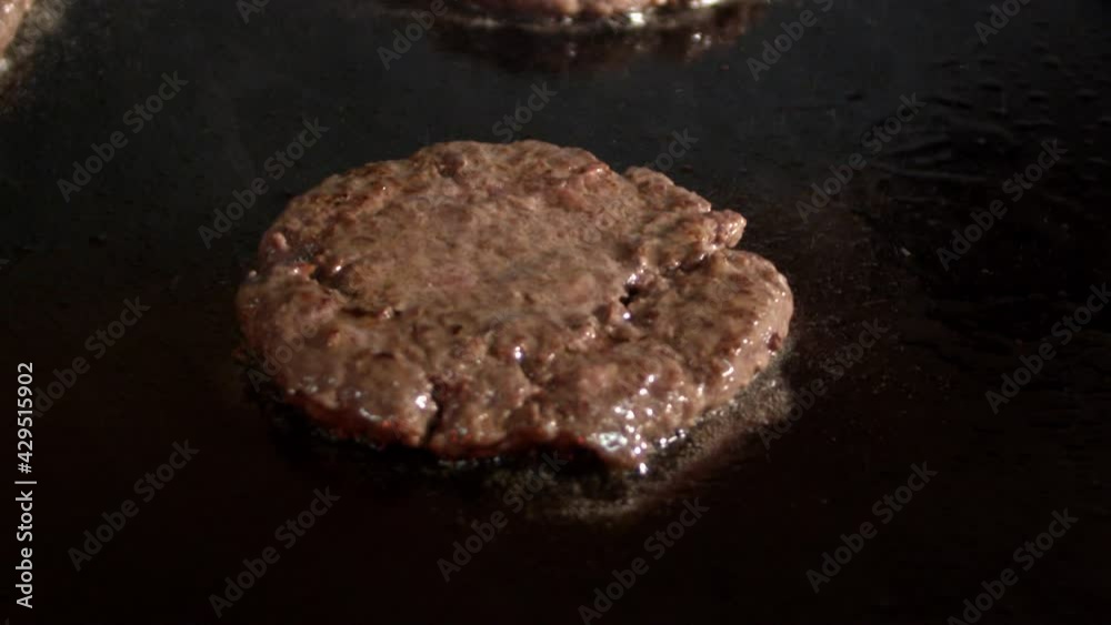 Close-up Of Roasted Meat On Grill. Hamburger meat being flipped on grill. Close-up Of Roasted Meat On Grill. Hamburger meat being flipped on grill.