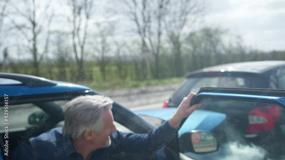 Senior Male Driver With Whiplash Injury Getting Out Of Car After Traffic Accident