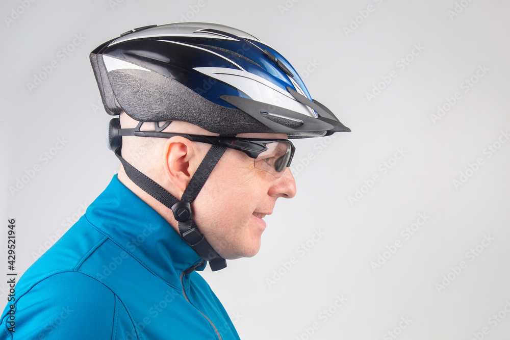 Male cyclist in a bicycle helmet and transparent glasses on a light background Male cyclist in a bicycle helmet and transparent glasses on a light background