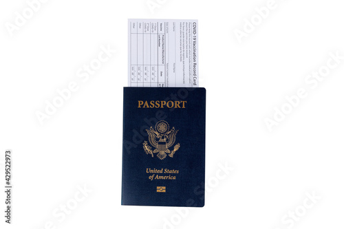 US Passport with Covid 19 vaccination record card placed inside of book isolated on white background.  Individual record for use during the covid 19 coronavirus pandemic