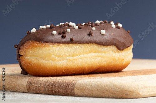 Obraz na plátne Traditional French dessert, eclair with chocolate on blue background