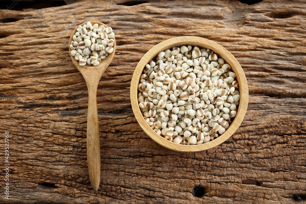 White millet seed raw in wood bowl on table White millet seed raw in wood bowl on table