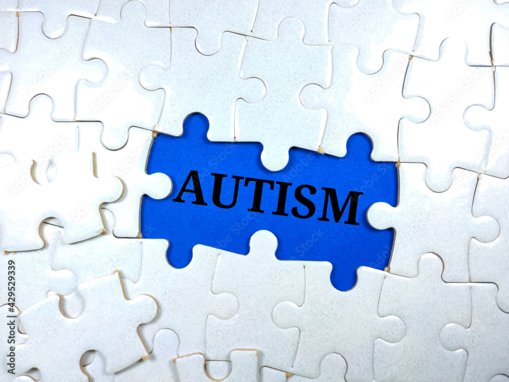 Selective focus.Word AUTISM with jigsaw puzzle on blue background. Selective focus.Word AUTISM with jigsaw puzzle on blue background.
