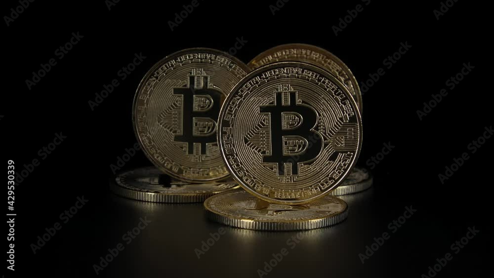 Golden Bitcoins on a black background. Close-up bitcoins. Dolly slowly. Crypto currency.