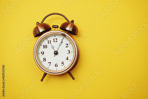 Vintage alarm clock with space copy on yellow background