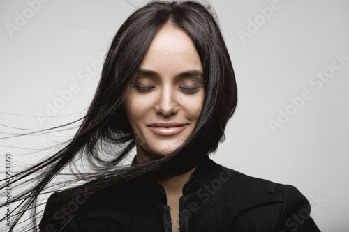 Beauty portrait of a smiling brunette girl with flying hair. Magnificent hair.