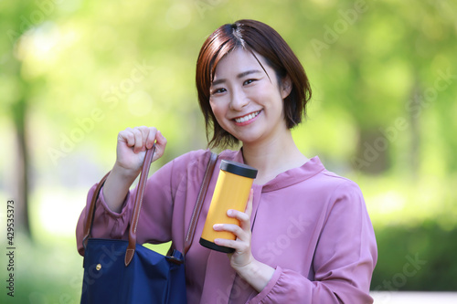 Fotografie 鞄から水筒を取り出す女性