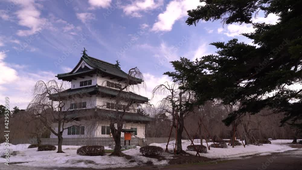 Wide open view of Hirosaki Castle during winter with person walking castle grounds Wide open view of Hirosaki Castle during winter with person walking castle grounds