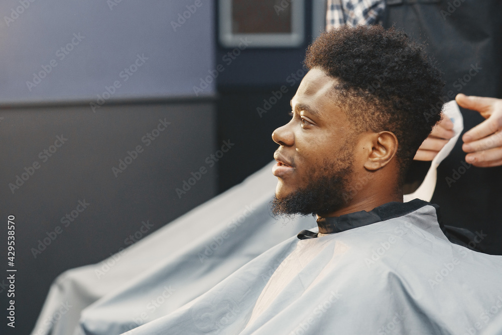 Young African-american man visiting barbershop Young African-american man visiting barbershop