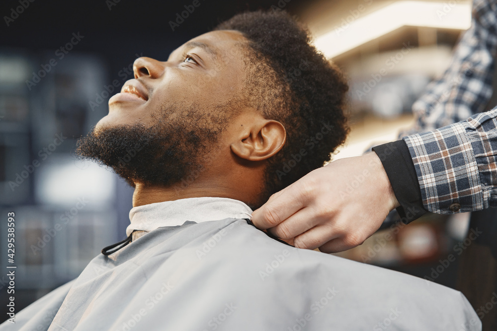 Young African-american man visiting barbershop Young African-american man visiting barbershop