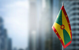 A small flag of Grenada on the background of a blurred background