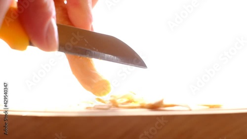 Misvak natural toothbrush. Cleaning the miswak stick.Female hands peeling the peel of miswak with a knife on a wooden board on a light blurred background photo