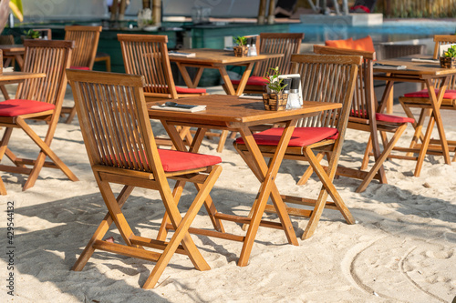 Wooden table and chairs in empty beach cafe next to sea. Close up  Thailand