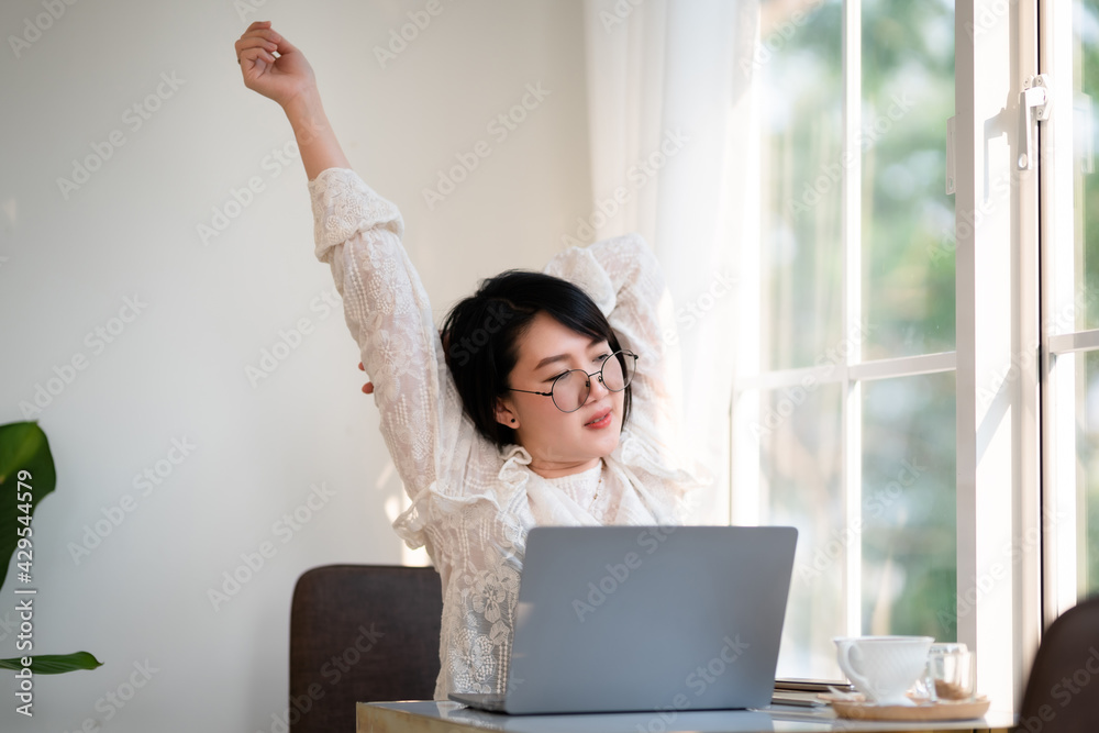 Happy Stretching Relaxation Resting of asian freelance people business female casual working with laptop computer with coffee cup and smartphone in coffee shop the background,communication concept Happy Stretching Relaxation Resting of asian freelance people business female casual working with laptop computer with coffee cup and smartphone in coffee shop the background,communication concept