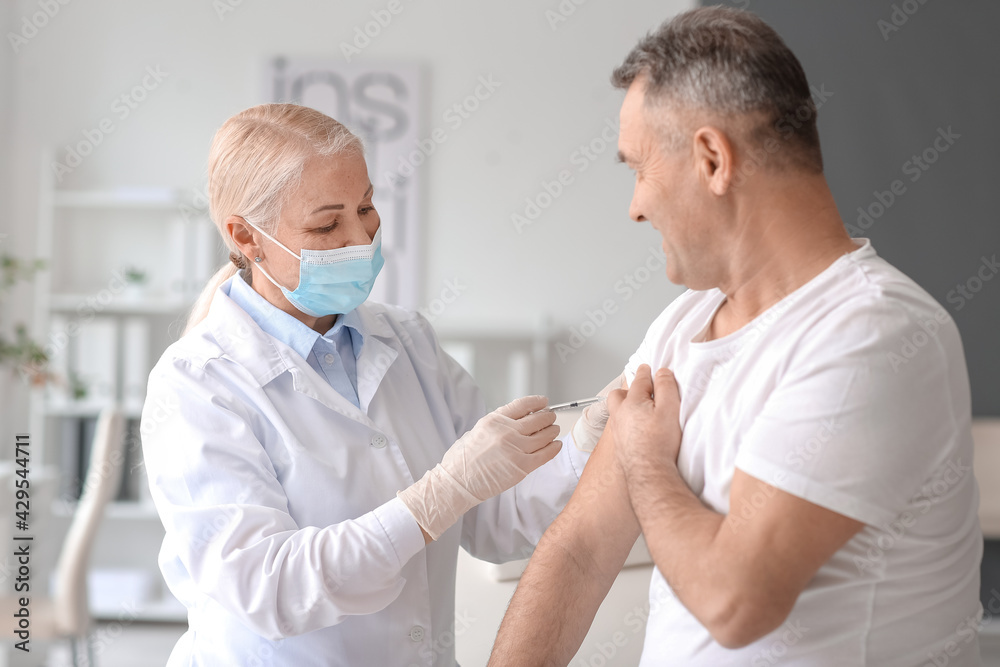 Fototapeta premium Doctor vaccinating patient in clinic
