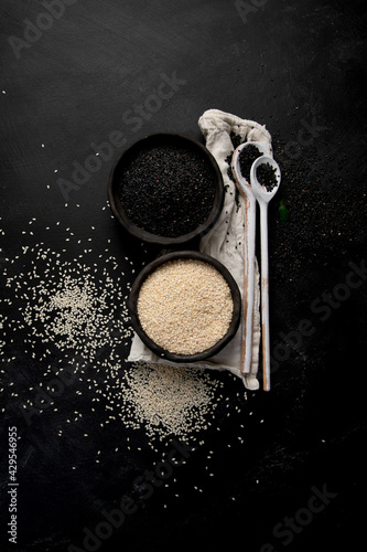 Black and white sesame seed on black background. Organic food concept