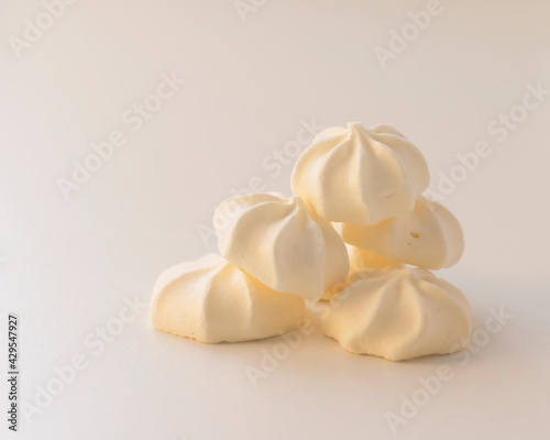 a bunch of cream meringues on a light background