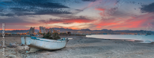 Scenic panoramic view with lonely old fishing boat anchored on a beach of the...