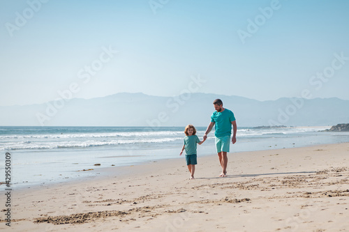 Father and son running on summer beach. Dad and child having fun outdoors. Family travel, vacation, father's day concept.
