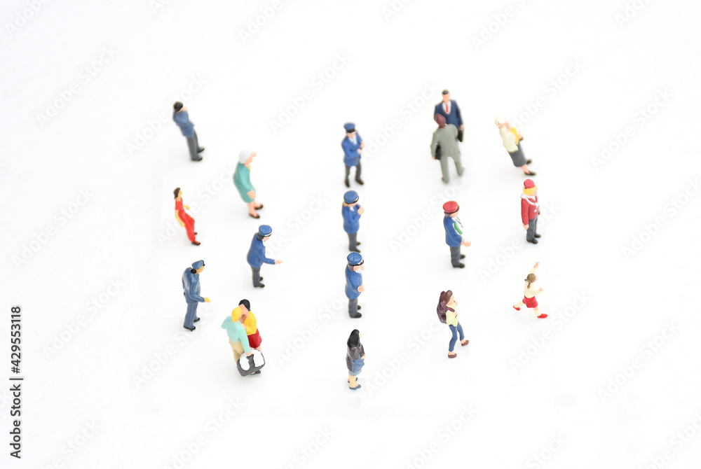 Top view group of miniature people in different colors costume, generation and career stand on white background. Concept communication of society and social distancing. selective focus. Top view group of miniature people in different colors costume, generation and career stand on white background. Concept communication of society and social distancing. selective focus.