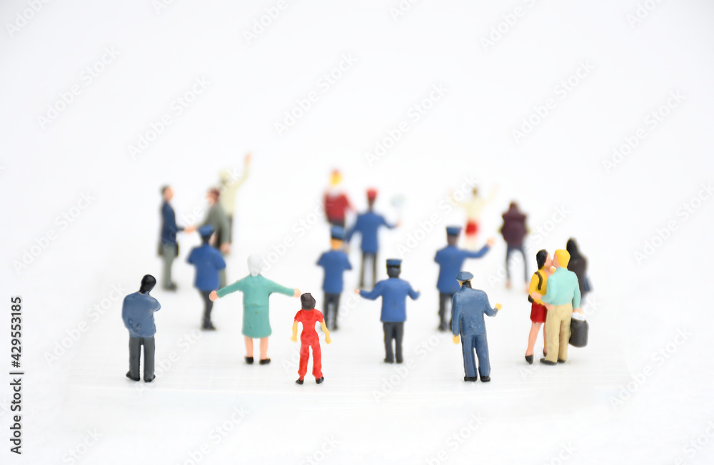 Top view group of miniature people in different colors costume, generation and career stand on white background. Concept communication of society and social distancing. selective focus. Top view group of miniature people in different colors costume, generation and career stand on white background. Concept communication of society and social distancing. selective focus.