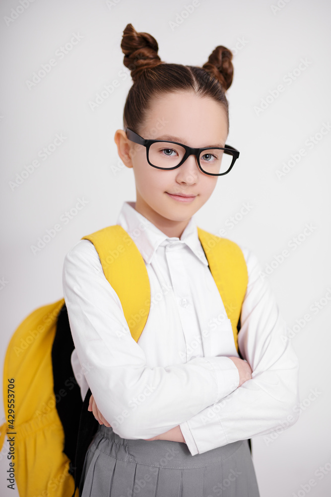 portrait of cute girl in school uniform and eyeglasses with backpack posing over white background portrait of cute girl in school uniform and eyeglasses with backpack posing over white background