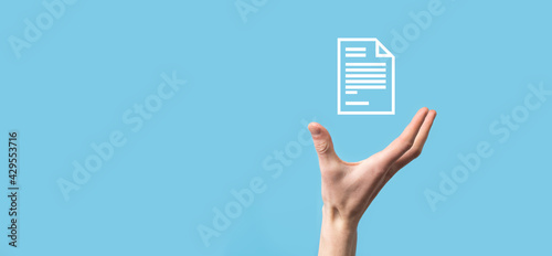 Male hand holding a document icon on blue background. Document Management Data System Business Internet Technology Concept. Corporate data management system DMS