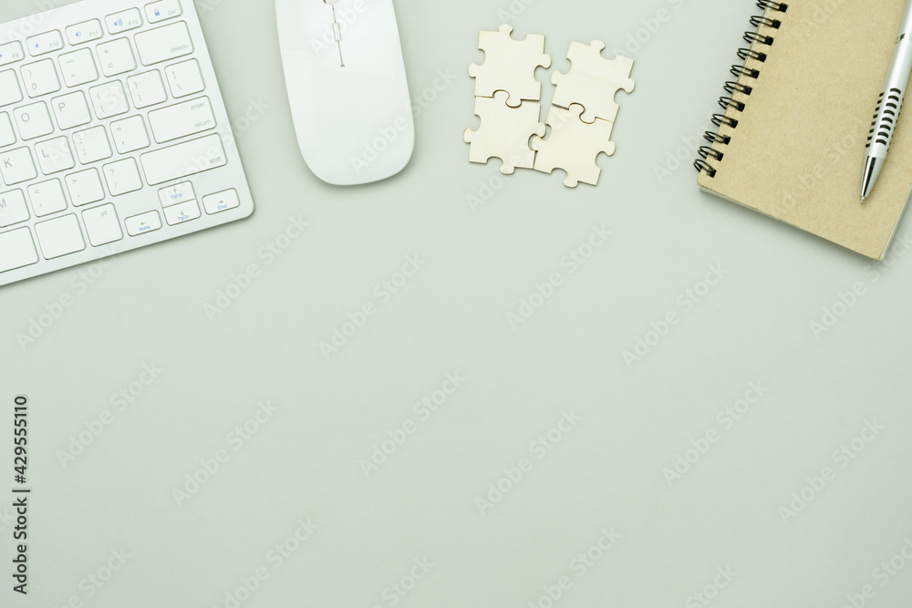 Top view essential accessories of working on table at office workplace. Flat lay pen keyboard mouse device notebook puzzle piece .copy space. Business and finance idea objects concept background. Top view essential accessories of working on table at office workplace. Flat lay pen keyboard mouse device notebook puzzle piece .copy space. Business and finance idea objects concept background.