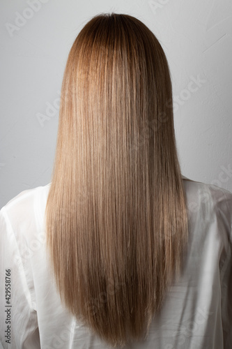 Long beautiful straight hair girl back view. Care, beauty salon, blonde, botox, keratin, result