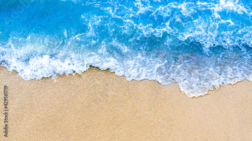 Wave of blue ocean on sandy beach background