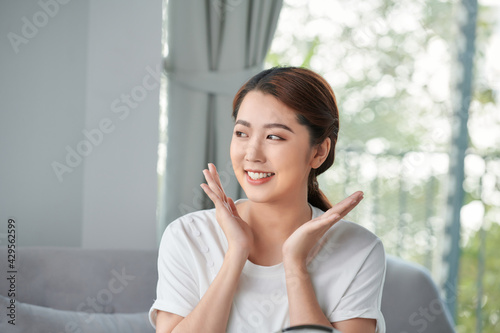 Beautiful young woman is touching her face and smiling while looking at the mirror Free Download Beautiful young woman is touching her face and smiling while looking at the mirror - GFXLoad