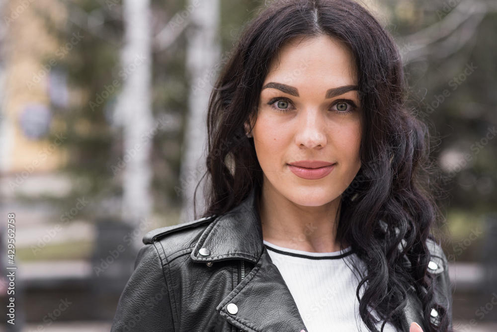 Beautiful brunette woman with curly hair posing on the street while walking Beautiful brunette woman with curly hair posing on the street while walking