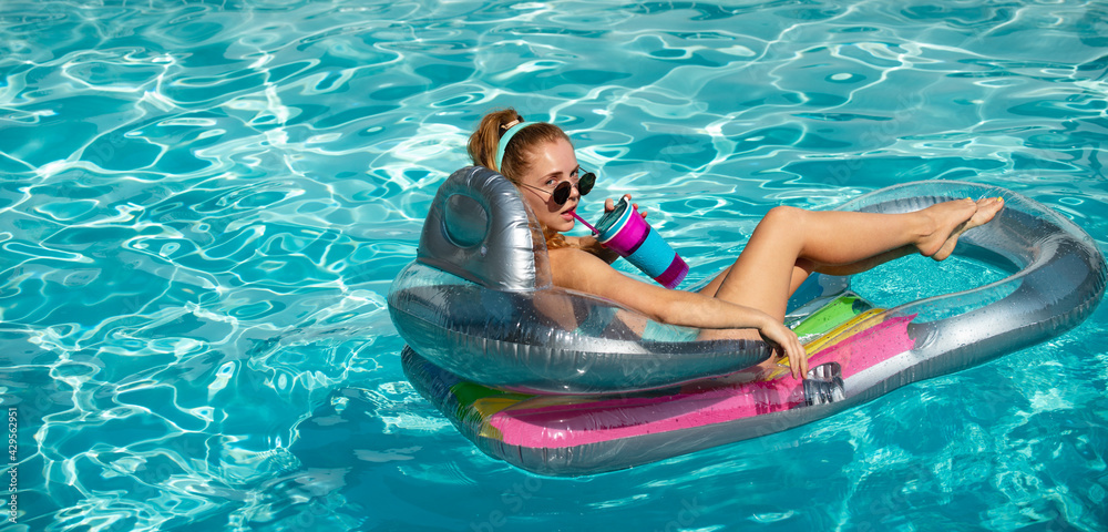 Vacation concept. Girl on inflatable mattress. Hot summer day. Pool resort.