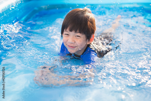 Cute Asian boy swimming and playing in a pool