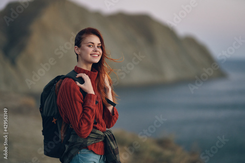 woman travels outdoors in the mountains in nature near the sea with a backpack