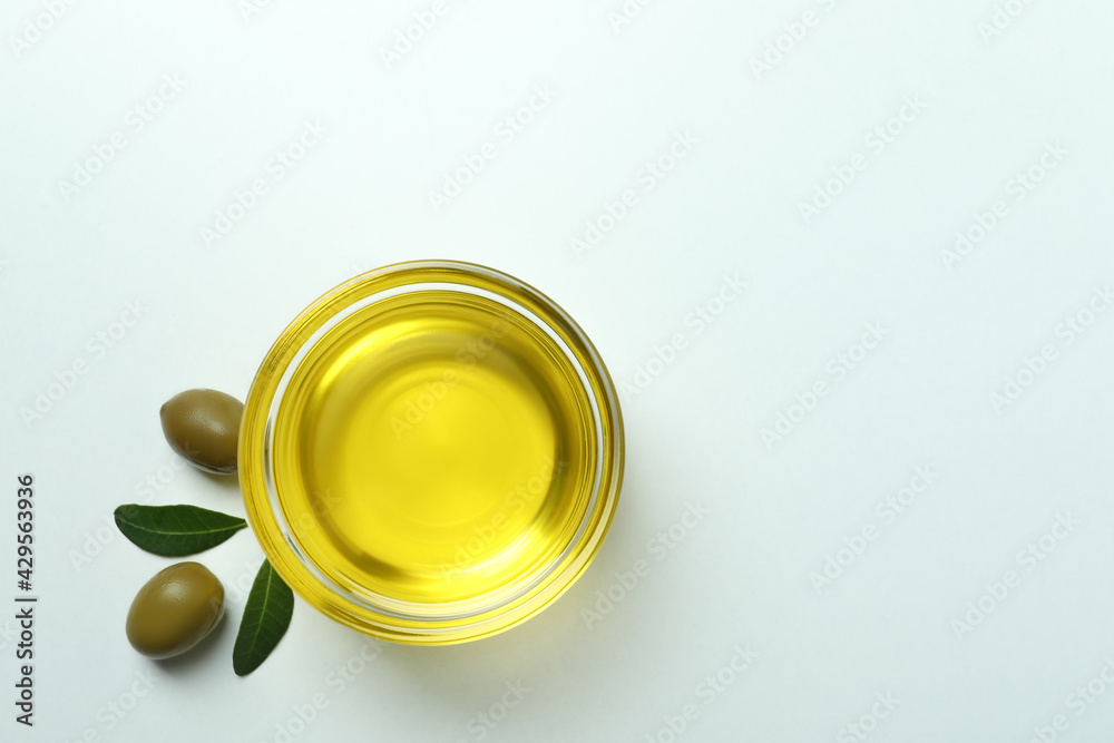 Bowl of oil, olives and leaves on white background Bowl of oil, olives and leaves on white background