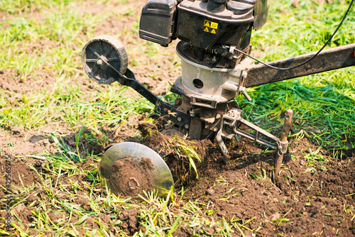 plowing machine working with soil at springtime farmland