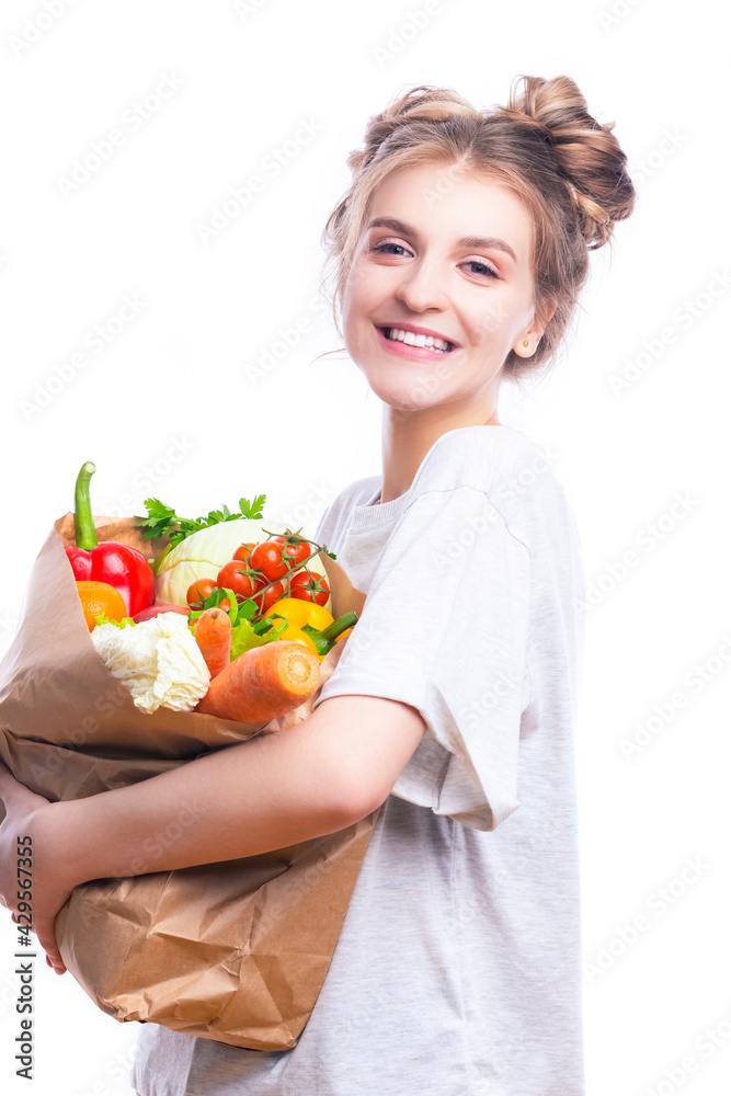 Laughing and Smiling Caucasian Female Holding Eco Paper Bag Filled With Multiple Vegetables and Groceries Against White Background. Laughing and Smiling Caucasian Female Holding Eco Paper Bag Filled With Multiple Vegetables and Groceries Against White Background.
