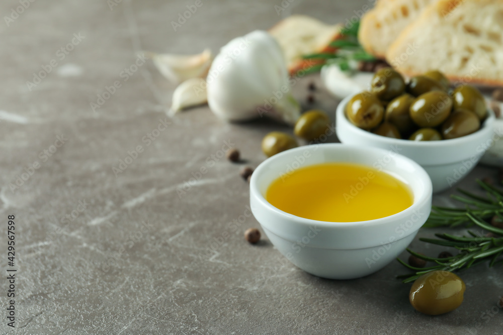 Concept of tasty eating with olive oil on gray textured table Concept of tasty eating with olive oil on gray textured table