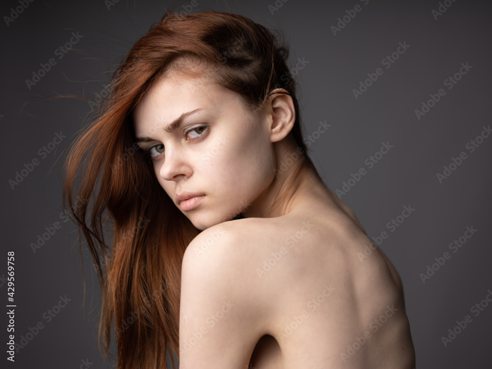 Red hair silk model gray background naked shoulders passionate look