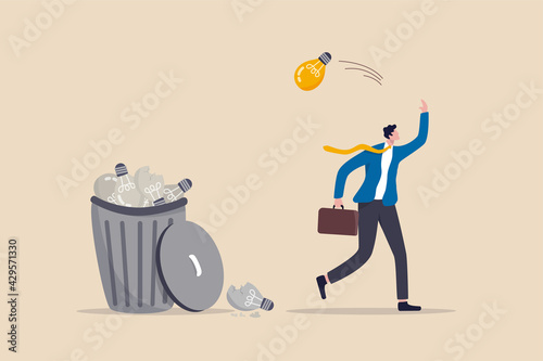 Wasted unworkable ideas, business failure or too many abandoned projects concept, frustrated businessman throw away lightbulb idea into full of junk idea in basket bin.