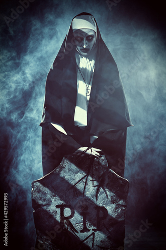 Fotografía dark nun at tombstone