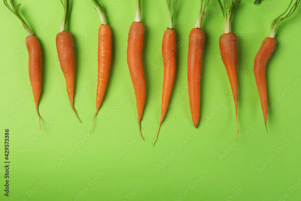 Fresh carrot on green background, space for text Fresh carrot on green background, space for text