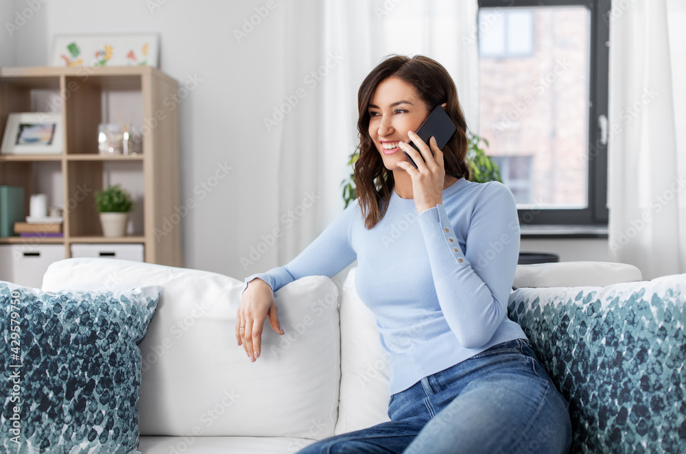 people, technology, communication and leisure concept - happy young woman calling on smartphone at home people, technology, communication and leisure concept - happy young woman calling on smartphone at home