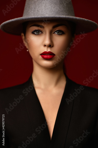 portrait of fashionable beautiful girl on red bakground.