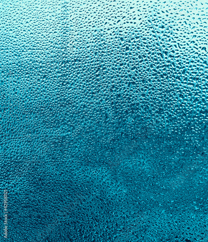 Raindrops on a cyan glass background.