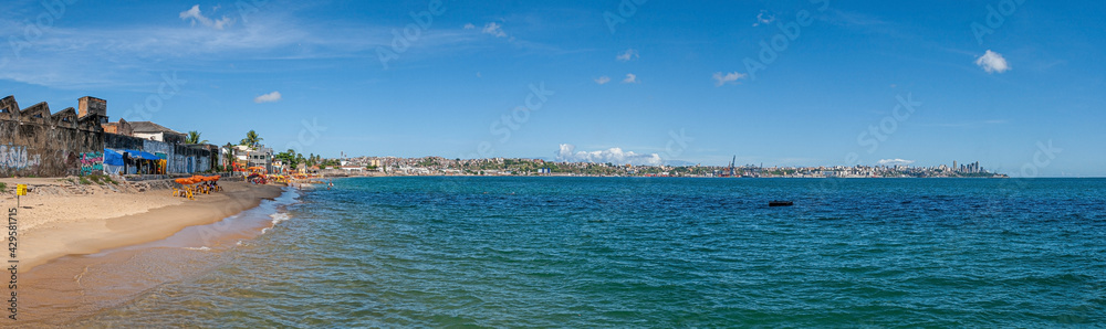 View of a simple city beach in Salvador de Bahia with industrial plants in the background